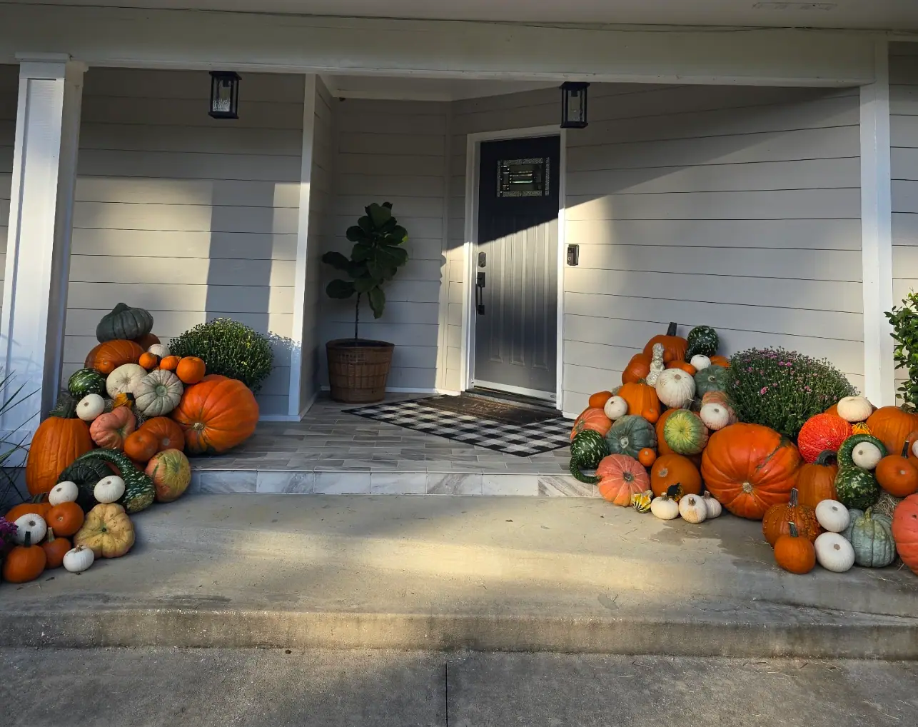 Front porch decorated with pumpkins and seasonal flowers